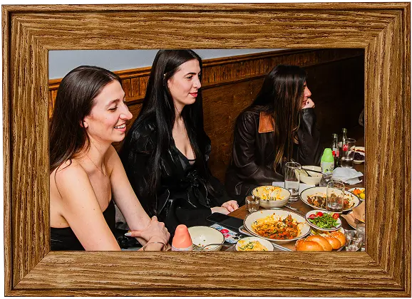 there are three women sitting at a table with food and drinks