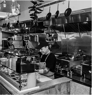 arafed kitchen with a lot of pots and pans hanging from the ceiling